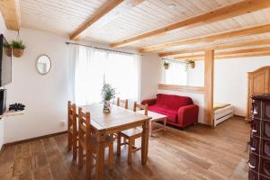 ein Wohnzimmer mit einem Tisch und einem roten Sofa in der Unterkunft Chalupa Těšínov in Protiwin