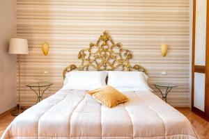 1 dormitorio con 1 cama blanca grande y cabecero dorado en Amalpha Domus Apartment en Amalfi