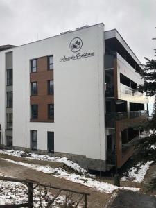 a building with a sign on the side of it at Armeria Residence 32 - Strbske pleso in Štrbské Pleso