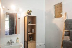 a bathroom with a sink and a toilet and a mirror at Vacances à la plage in Sainte-Anne +32 photos
