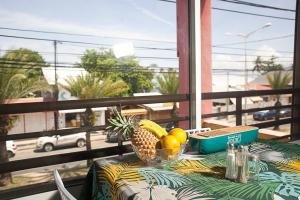 une table avec un ananas et des fruits sur un balcon dans l'établissement Vacances à la plage, à Sainte-Anne