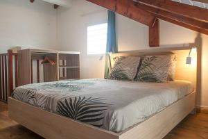 a bedroom with a large bed with a wooden frame at Vacances à la plage in Sainte-Anne