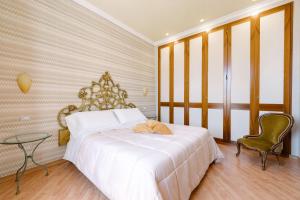 1 dormitorio con 1 cama blanca grande y 1 silla en Amalpha Domus Apartment en Amalfi