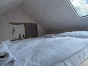 a large white bed in a room with a window at Posedy Panský dvůr Telč in Telč