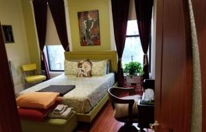 um quarto com uma cama com um cão sentado nela em Spacious Fully Furnished Harlem Apartment Near Morningside Park em Nova Iorque