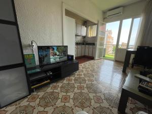 a living room with a television and a tile floor at NICE APARTAMEN in Lloret de Mar