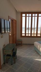 a living room with a television and a table at Riad Mellah in Essaouira