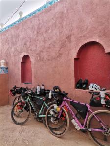 two bikes parked next to a red wall at Riad Dades Birds in Boumalne