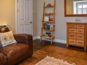 - un salon avec un canapé en cuir brun et une commode dans l'établissement Flint House, à Sheringham