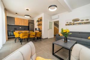 een woonkamer met een bank, een tafel en stoelen bij Villa Petra 1 - private pool in Novalja