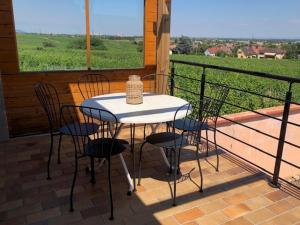 einen Tisch und Stühle auf einem Balkon mit Blick auf ein Feld in der Unterkunft Les trois pierres in Eguisheim
