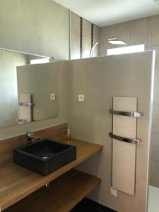 a bathroom with a black sink and a mirror at Les trois pierres in Eguisheim