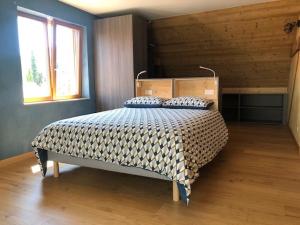 ein Schlafzimmer mit einem Bett in einem Holzzimmer in der Unterkunft Les trois pierres in Eguisheim