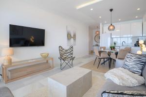 a living room with a couch and a tv and a table at La Luz de la Luna in Costa Teguise