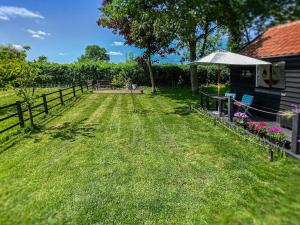 a yard with a fence and a table and chairs at The Little Barn in Hoxne