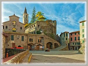 a large stone building with a clock tower and a church at B&B Da Giua' in Apricale