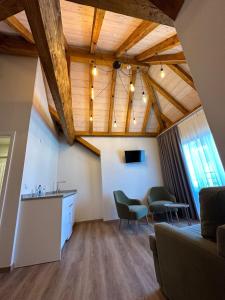 a living room with wooden ceilings and green chairs at Hotel Le Postillon in Echternach