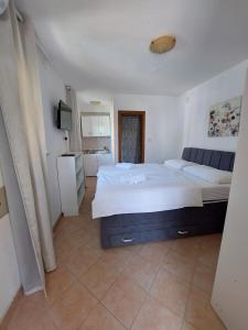a bedroom with a large white bed and a kitchen at Guest House Nina in Novigrad Istria