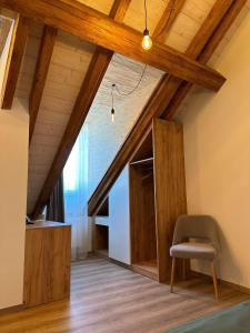 Zimmer im Dachgeschoss mit Holzdecken und einem Stuhl in der Unterkunft Hotel Le Postillon in Echternach