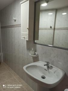ein Bad mit einem Waschbecken und einem Spiegel in der Unterkunft ATICO AS CORTIÑAS in O Grove