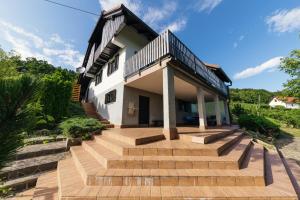 una casa con una escalera que conduce a ella en Cosy Hill Home Rucman With a Breathtaking View, en Zgornja Pohanca