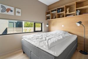 een slaapkamer met een bed en een groot raam bij Oceanfront penthouse duplex wamazing view! in Tromsø