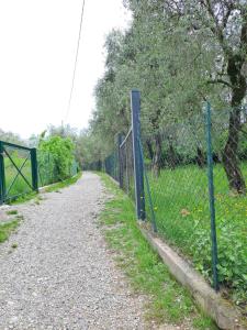 a fence on the side of a dirt road at Appartamento Ciclamino in Malcesine