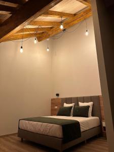 Schlafzimmer mit einem Bett mit Deckenbeleuchtung in der Unterkunft Hotel Le Postillon in Echternach