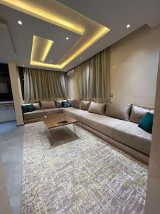 a living room with a couch and a coffee table at Appartement Gold moderne avec hammam centre ville in Agadir