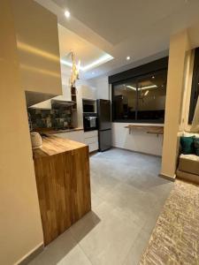 a large kitchen with a counter and a large window at Appartement Gold moderne avec hammam centre ville in Agadir