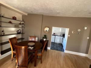a dining room with a table and chairs and a kitchen at Stay in Yeovil Town Centre, Large 2 BD Apt With Parking, Sleeps 4 in Yeovil