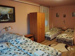 ein Hotelzimmer mit 2 Betten und einem Schrank in der Unterkunft Mónika Vendégház in Egerszalók