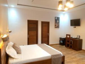 a bedroom with a bed and a television in it at SOA LIA HOTEL in Miandrivazo