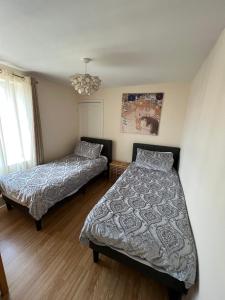 a bedroom with two beds and a chandelier at Yeovil Town Centre - Large 2 Bedroom Apt With Parking in Yeovil