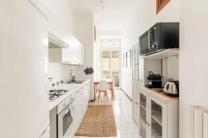 a white kitchen with white cabinets and a table at Imperial Nazionale in Rome