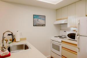 a kitchen with a sink and a white refrigerator at 1 bed family friendly condo on quiet Blackcomb - sleeps 5 in Whistler