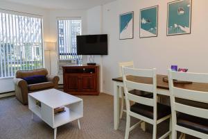 een woonkamer met een tafel en een televisie bij 1 bed family friendly condo on quiet Blackcomb - sleeps 5 in Whistler
