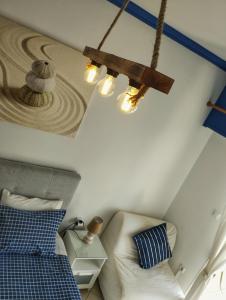 a bedroom with a blue and white bed and lights at CozyCoast in Rafina