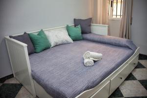 - un lit avec une couette violette et des serviettes dans l'établissement Teniente Bago, à Jaén