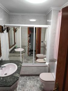 La salle de bains est pourvue de 2 lavabos, de toilettes et d'un miroir. dans l'établissement Teniente Bago, à Jaén