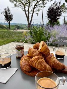 una mesa con un plato de pan y dos vasos de café en Villa Bricco 46, en Nizza Monferrato