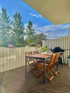 une table et des chaises en bois sur une terrasse dans l'établissement Sunnuhlíð 19, à Akureyri