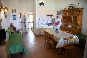 a kitchen and dining room with a table and chairs at Alloggio incantevole con piscina in Ricadi