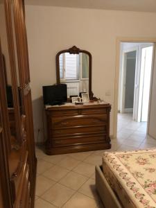 a bedroom with a dresser with a mirror and a bed at Casa Marisa in Ponsacco