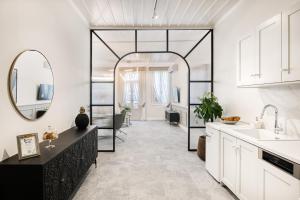 uma cozinha com armários brancos e um espelho grande em Mavrogenous Luxury Apartments em Nafplio