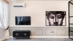 una sala de estar con 3 cuadros en la pared en Mavrogenous Luxury Apartments en Nafplio