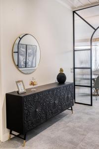 uma cómoda preta num quarto com um espelho em Mavrogenous Luxury Apartments em Nafplio