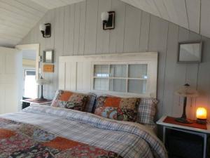 ein Schlafzimmer mit einem Bett mit Kissen und einem Fenster in der Unterkunft Dory Buff House in Princeton