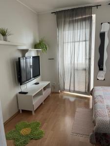 a living room with a television on a white cabinet at Apartment Sofia with terrace & parking in Bratislava