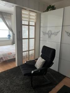a black chair in a room with a bedroom at Apartment Sofia with terrace & parking in Bratislava